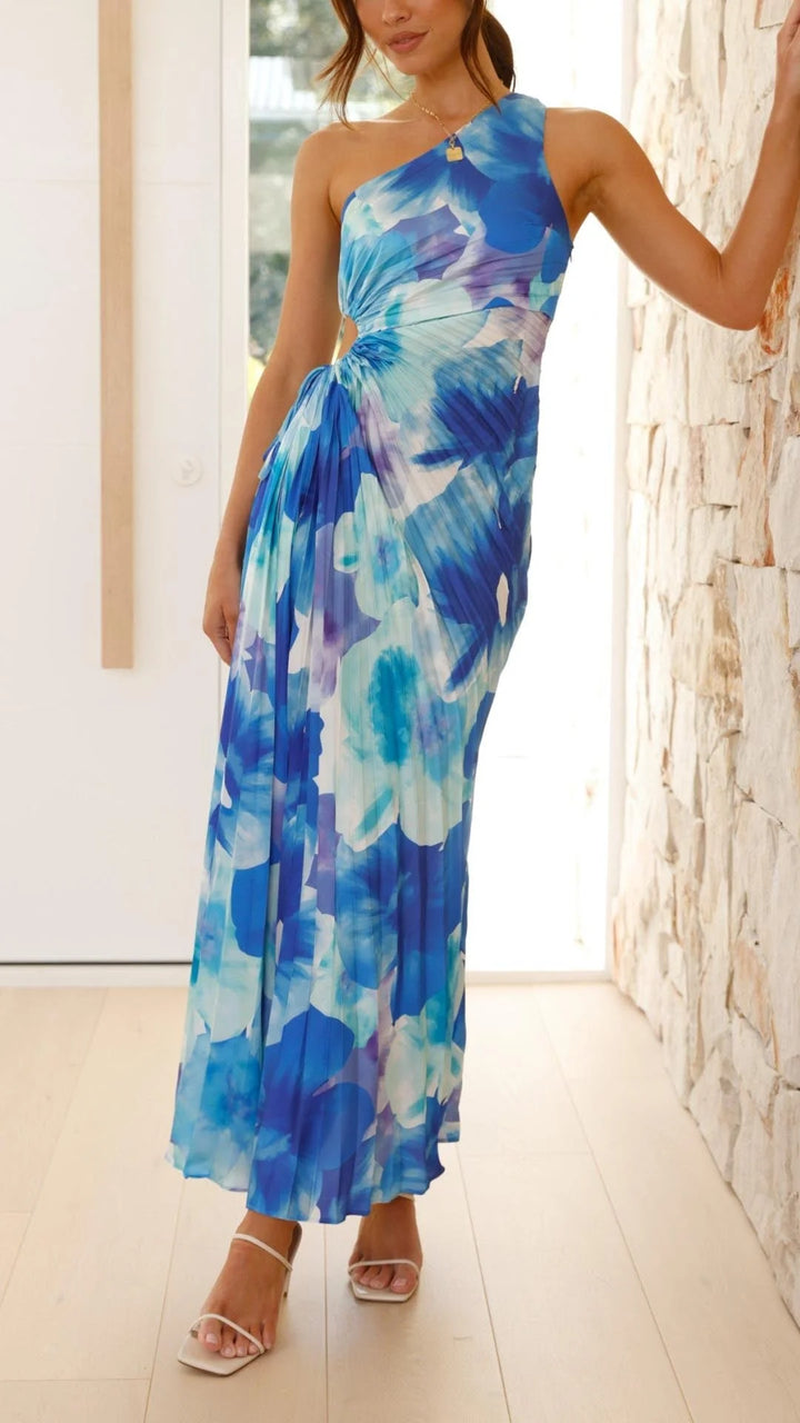 Blue floral pleated maxi dress with asymmetrical design. Features a flattering silhouette and soft, flowy fabric perfect for…