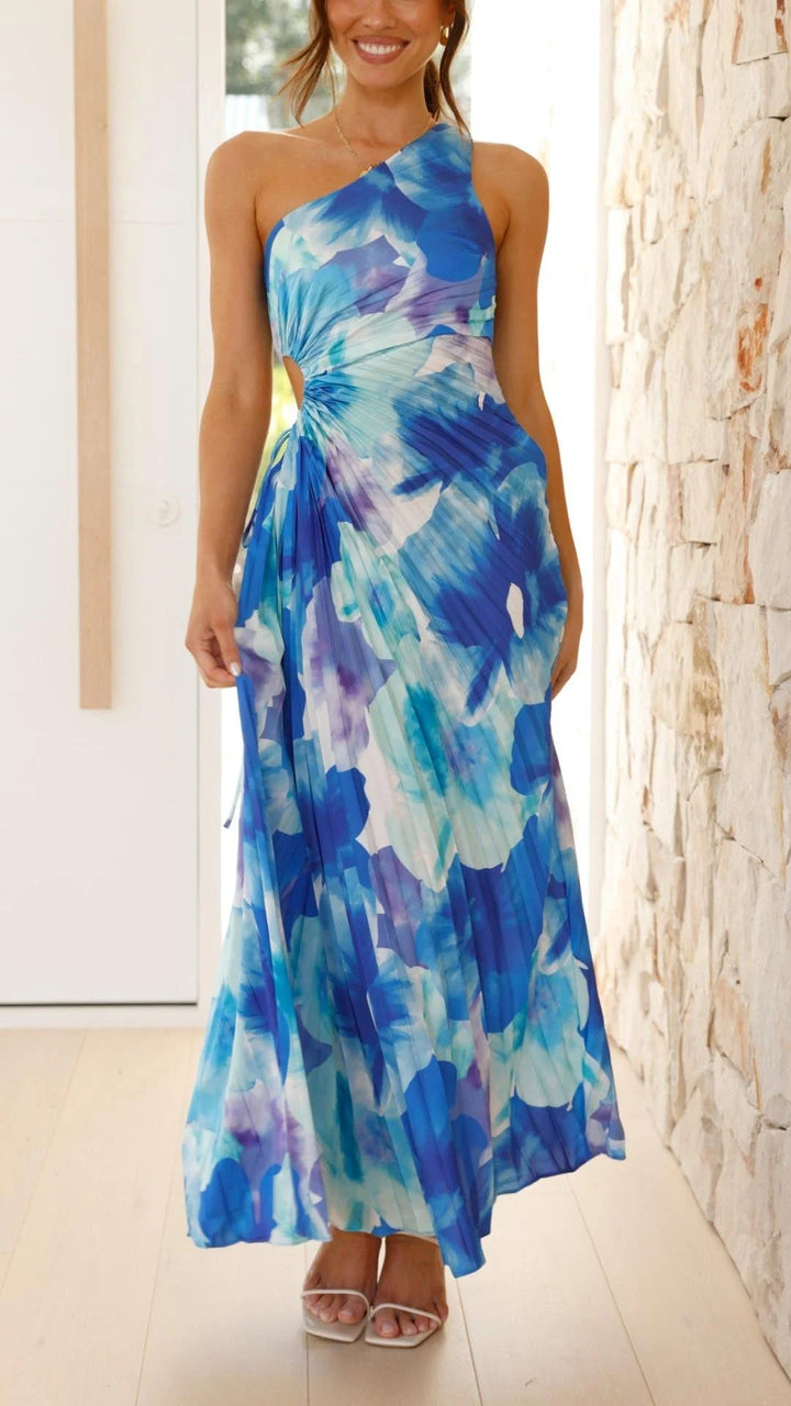 Blue floral pleated maxi dress with asymmetrical design made of lightweight, flowy fabric for a chic and elegant look.