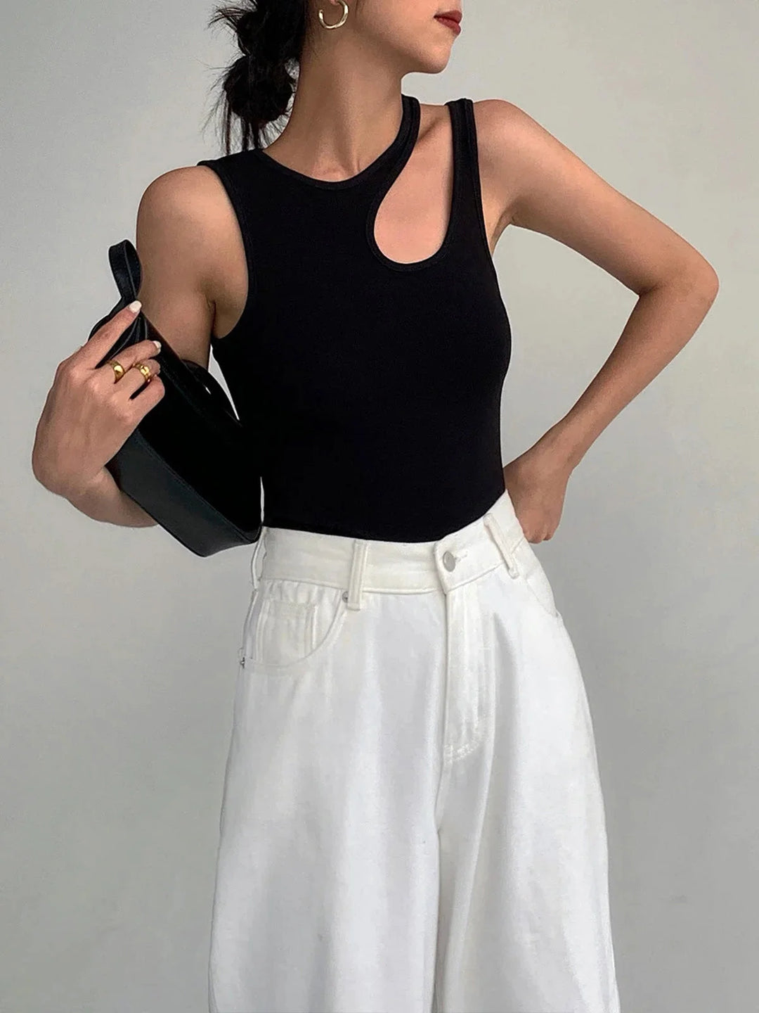 Asymmetric ribbed knit sleeveless top showcasing modern design with ribbed detailing and a unique silhouette.