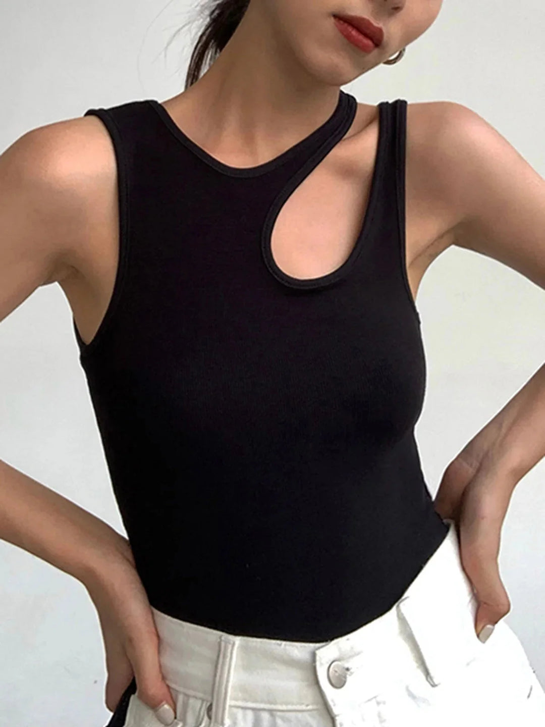 Black sleeveless top with asymmetric ribbed knit design. Textured material adds depth to the modern silhouette.
