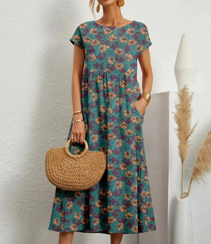 Blue floral print midi dress made of soft cotton fabric by Vivia. Ideal for a casual chic look in any season.