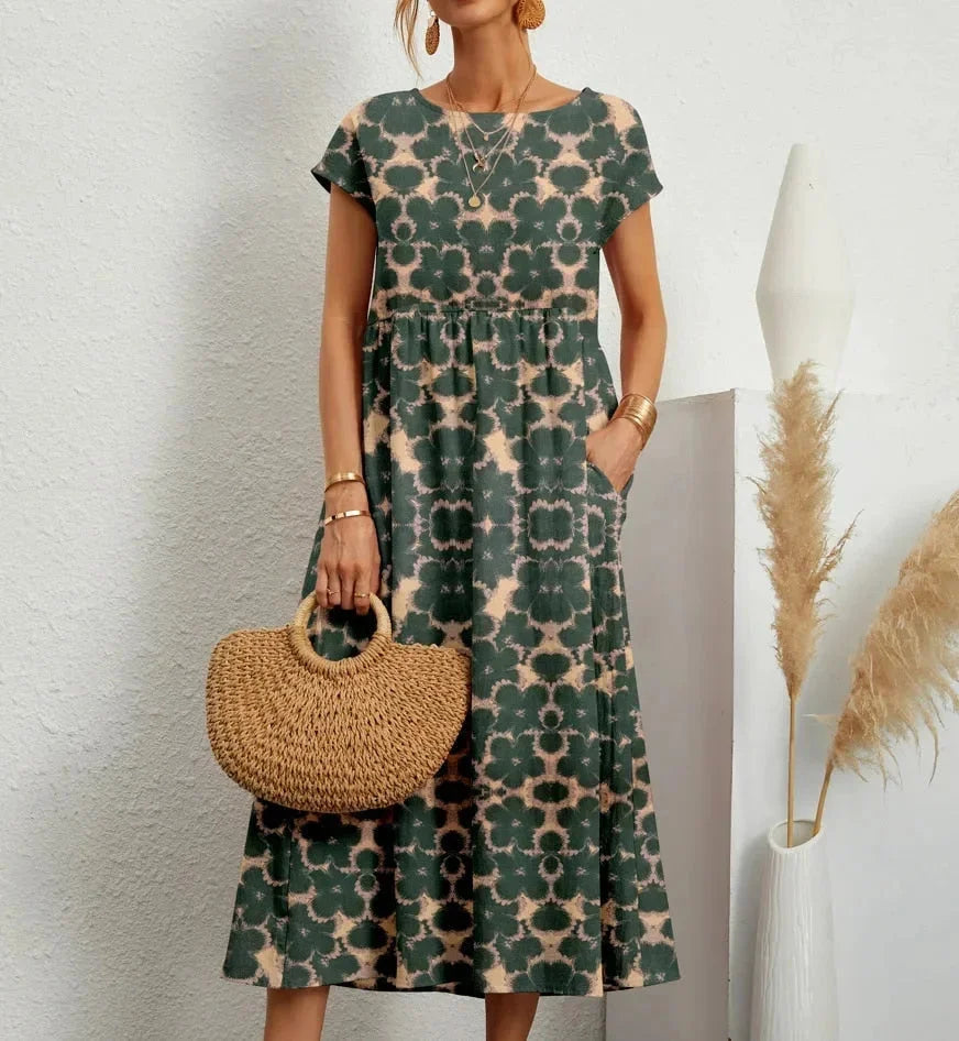 Green cotton midi dress with floral print. Features a flattering silhouette ideal for everyday wear.
