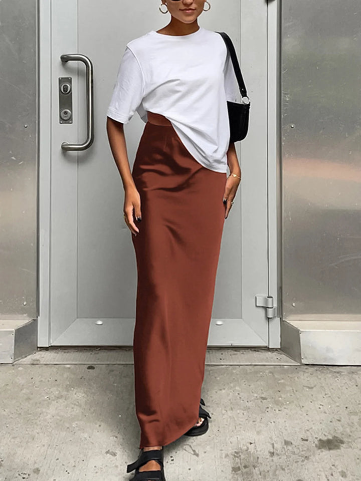 Dark brown flowy satin maxi skirt showcasing a flattering A-line silhouette and silky-smooth texture for an effortlessly…