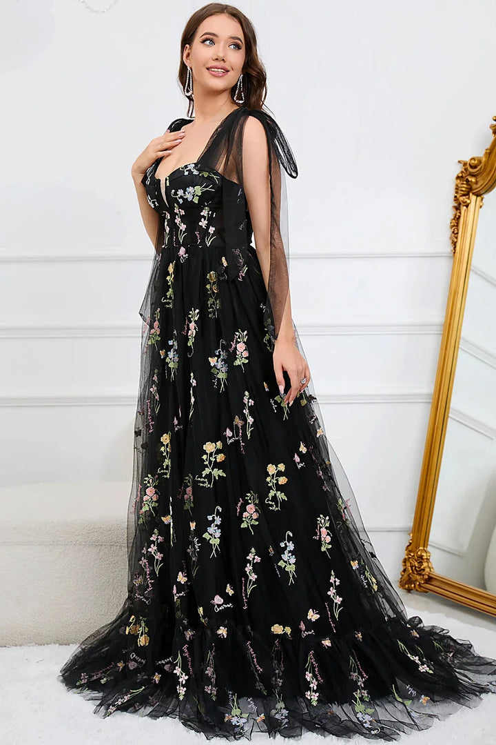 Embroidered tulle dress with sheer overlay showcasing intricate floral patterns and elegant design.