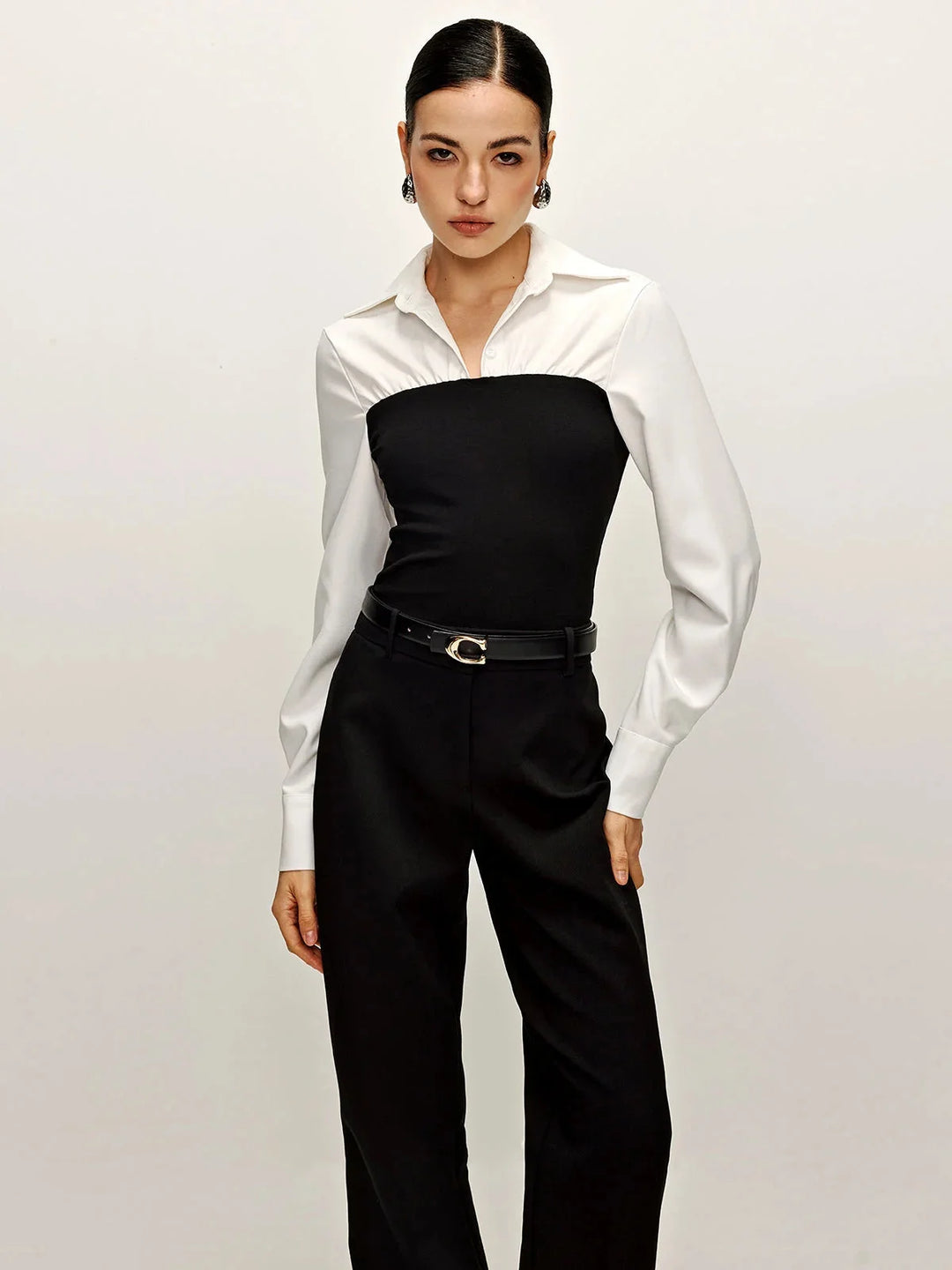 "Black and white tailored blouse with contrasting collar, sophisticated two-tone design for versatile styling."