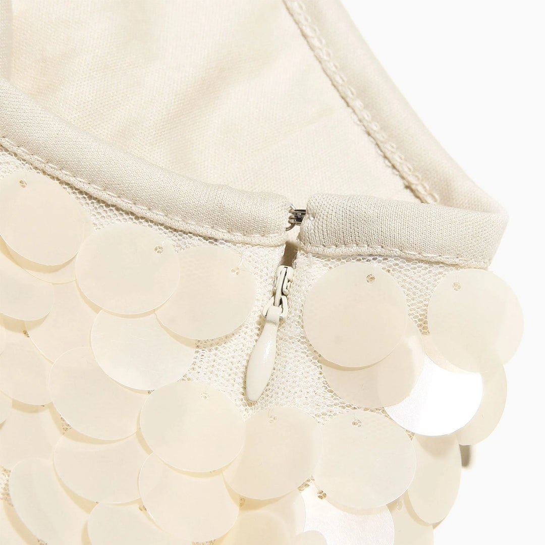 Ivory sequin mini skirt with sparkling design, perfect for adding a touch of glamour to your outfit.