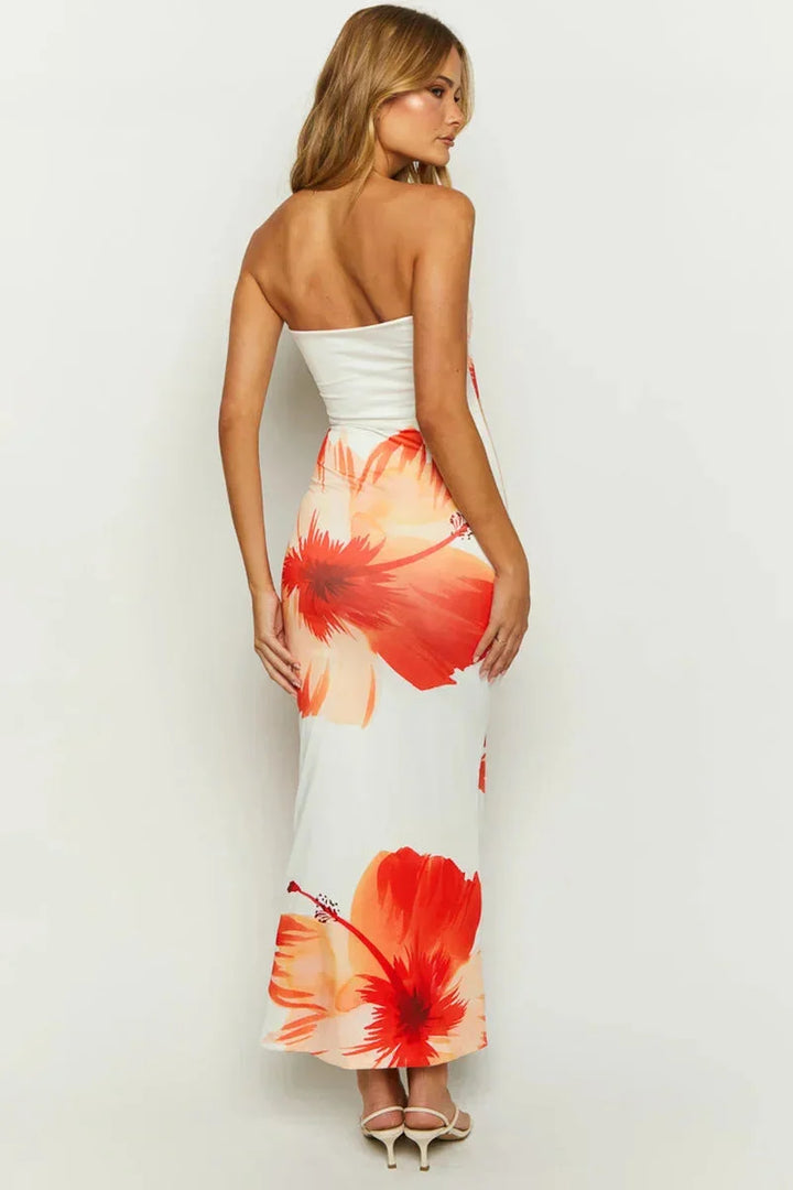 Strapless white and orange floral maxi dress with a flowing silhouette, perfect for summer days and made with comfortable…