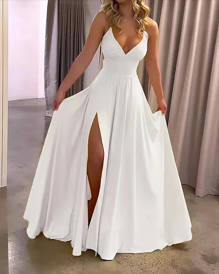 "White flowing maxi dress with deep slit, made from lightweight fabric. Perfect for a breezy, elegant look."