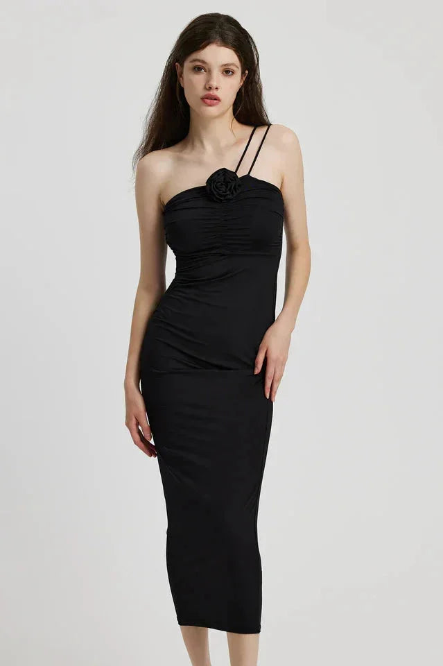 "Sleek black midi dress with sculptural floral detail, perfect for a touch of modern elegance"