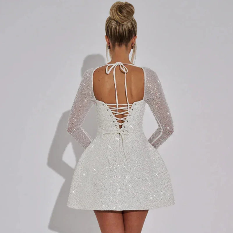"Zola - Sparkling mini dress with sheer long sleeves in silver sequins and mesh fabric."